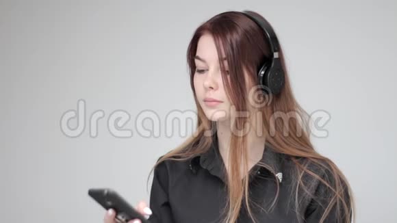 年轻漂亮的女士无线耳机使用平板电脑和手机拍照视频的预览图