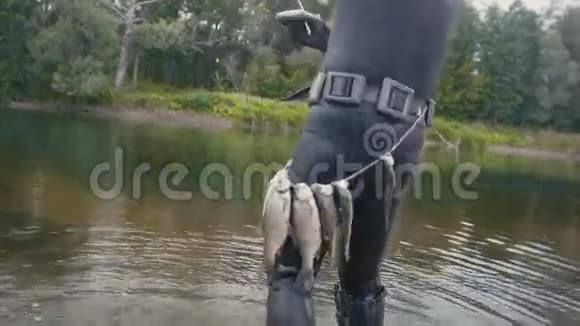长矛渔民展示了水下渔民在森林河狩猎后带上的淡水鱼后景视频的预览图