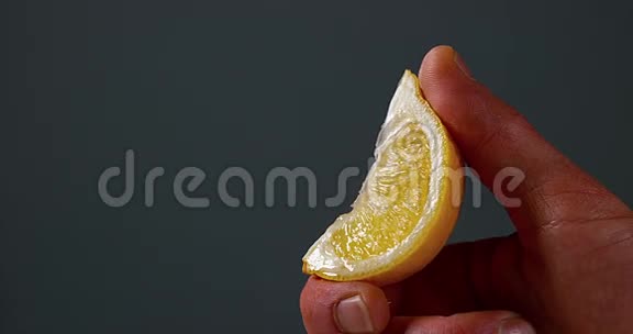 男人的手在黑色背景下压榨柠檬柑橘柠檬视频的预览图