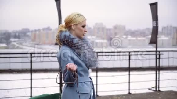 摄影的冬季大衣收藏为封面的杂志在一个漂亮的模特面前摆姿势视频的预览图