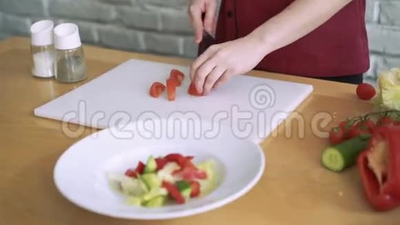 女人切西红柿做蔬菜沙拉准备在餐厅厨房4k视频的预览图