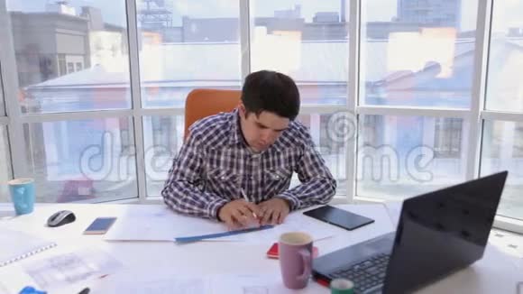 一个自信而有魅力的商人在一个轻盈现代化的办公室里用图纸蓝图工作商业概念视频的预览图