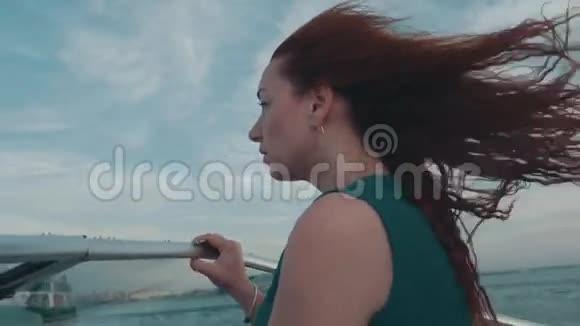 红发少女穿着绿松石裙驾驶摩托艇夏日之夜风大自然视频的预览图