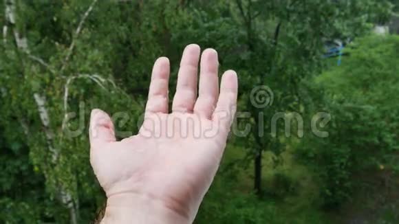 男人手在雨下收集雨滴视频的预览图