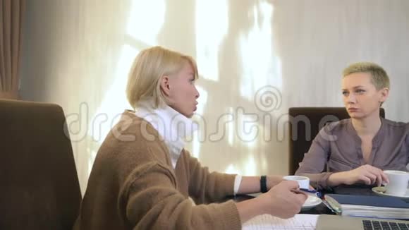 两个女人坐在笔记本电脑前的办公室里说话视频的预览图