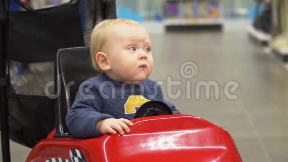 婴儿坐在商店的购物车里视频的预览图