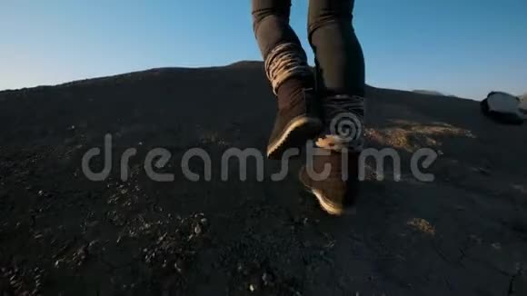 年轻迷人的女孩徒步旅行者沿着沙质悬崖或海边悬崖举起双手看着金色视频的预览图