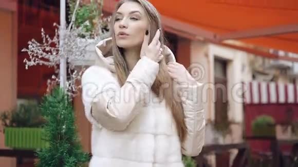 时尚模特穿着毛皮外套在街上摆姿势拍照视频的预览图