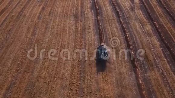 空中无人机拍摄的联合收割机在一个领域工作在日落在4K中被击中季节结束时播种视频的预览图