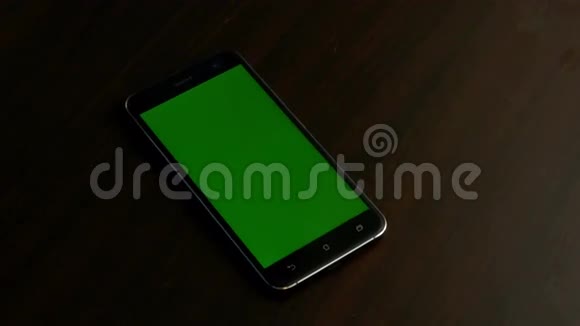 木质背景盒内带有彩色绿色屏幕的手机视频的预览图