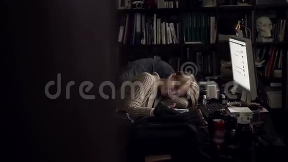 一个女孩躺在办公桌上拿着平板电脑视频的预览图
