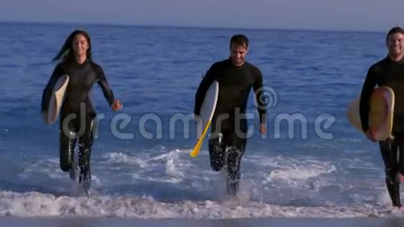 三个快乐的冲浪者逃离大海视频的预览图