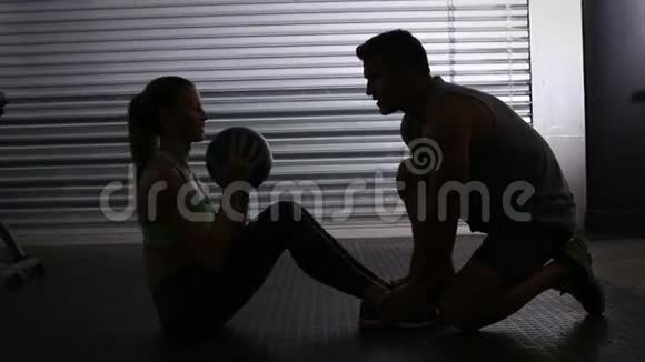 健身女人做加权坐教练视频的预览图