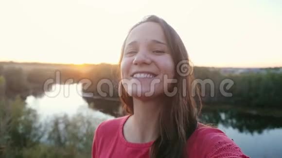美丽的年轻女子在日落时在岩石上慢镜头自拍1920x1080视频的预览图