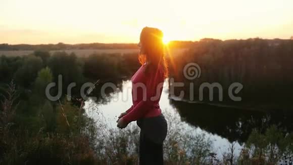 美丽的女孩在日落或日出时缓慢地在山上做瑜伽1920x1080视频的预览图