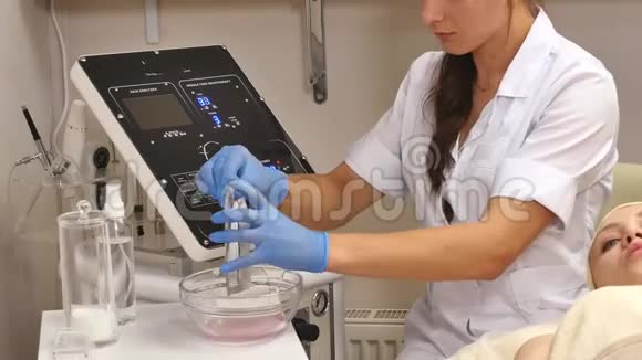 美容师用玻璃碟子从管子里挤出奶油双手戴医用手套视频的预览图