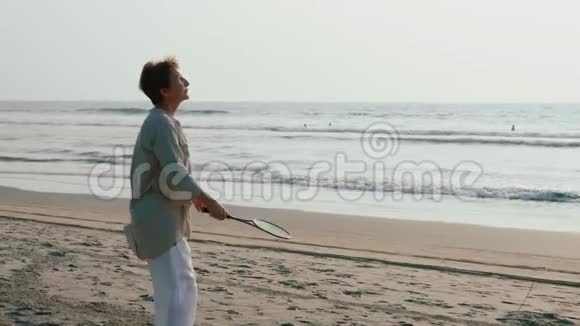 活跃的老夫妇在海滩上缓慢地打太极球视频的预览图