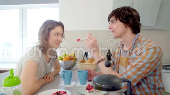 夫妻俩喝茶看着对方的眼睛男人用美味的蛋糕勺子喂他的女朋友视频的预览图