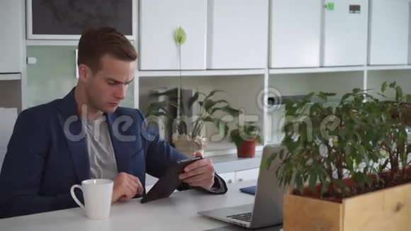 商人大约30多岁在触摸屏平板电脑上阅读视频的预览图