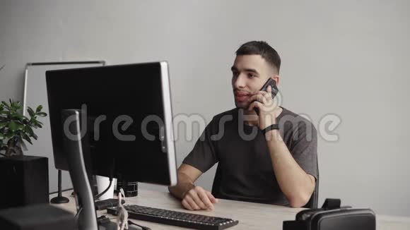 年轻的商人学生或自由职业者穿着衬衫坐在电脑旁在桌子旁敲键盘视频的预览图