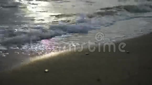 海滩上的涅槃平静的田园风光海上金色日落的景象波浪在沙滩上缓缓飞溅视频的预览图