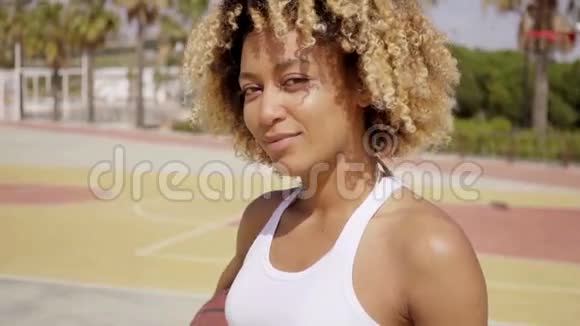 一位年轻的女运动员带着篮球走路视频的预览图