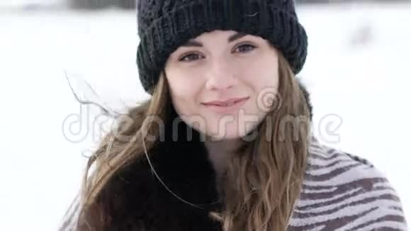 迷人的女孩微笑着看着寒风刺骨的冬日视频的预览图