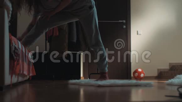 客厅里年轻的黑发女人滑倒在地毯上不小心弄裂视频的预览图