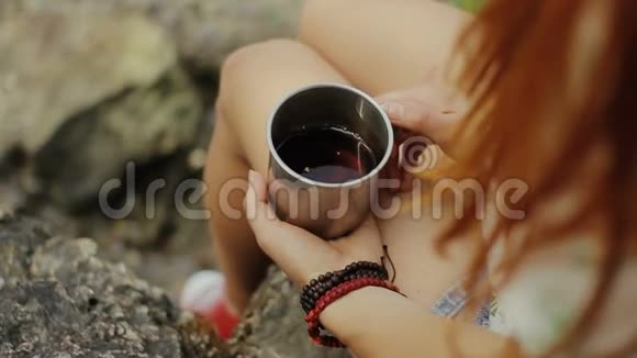 女孩拿着一杯热茶女孩在森林里喝茶视频的预览图