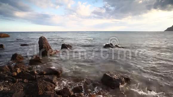 平静的海浪大海清澈的海水抚摸着石头和鹅卵石的特写声音海洋卵石的背景视频的预览图