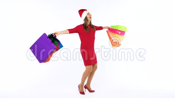 一美元的钞票落在圣诞购物妇女身上她带着五颜六色的购物袋在白色背景下疯狂地跳舞视频的预览图