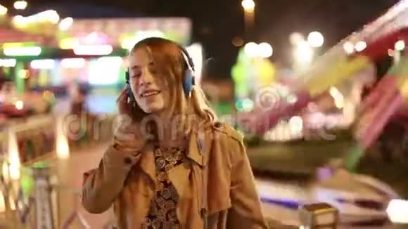 金发女孩带着耳机随着音乐的节奏跳舞视频的预览图