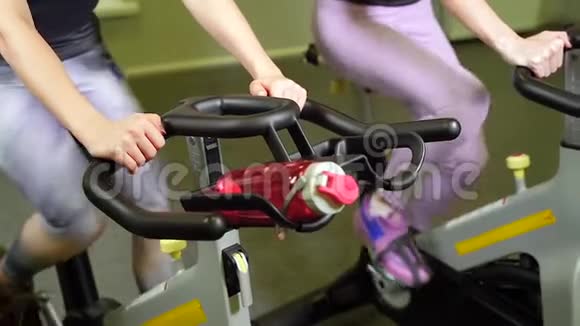 年轻女子在健身房骑自行车视频的预览图