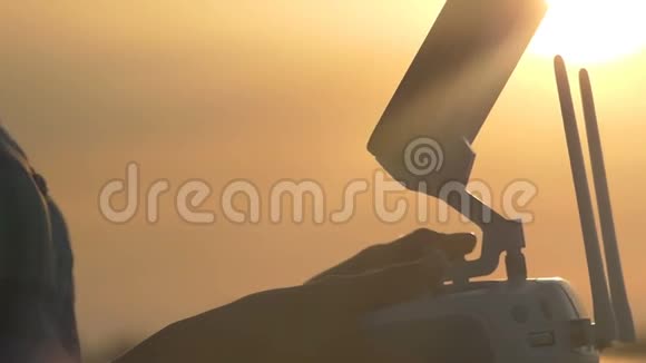 日落时分女性手操纵无人机控制面板视频的预览图