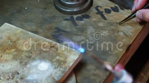 女工吹火把熔化金属的特写镜头视频的预览图