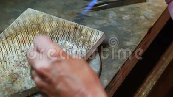 女工吹火把熔化金属的特写镜头视频的预览图