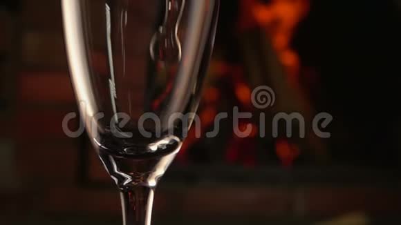 香槟酒在火的背景下倒入玻璃杯中视频的预览图