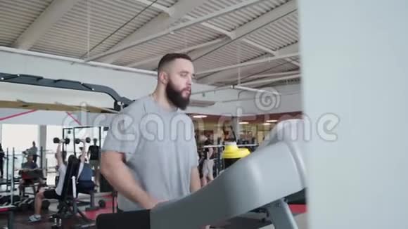 英俊的运动员在健身房的跑步机上锻炼视频的预览图