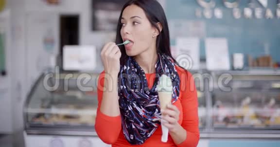 微笑的年轻女子品尝冰淇淋蛋卷视频的预览图