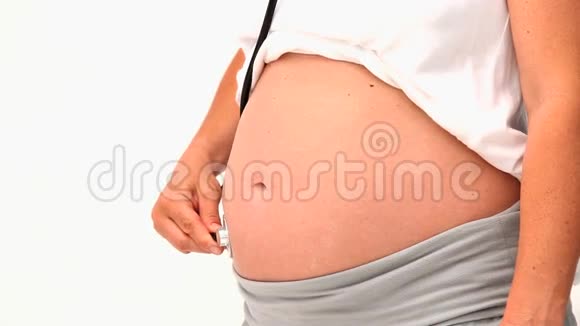 孕妇用听诊器倾听她的腹部视频的预览图