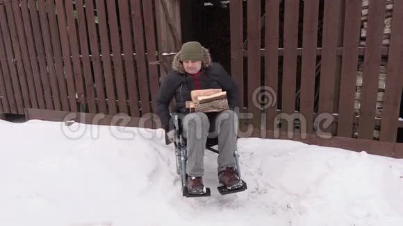 轮椅上的残疾人在谷仓附近拿着木柴视频的预览图