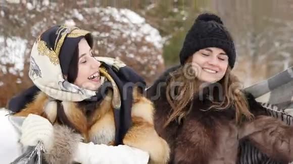 两个穿着格子布的女孩在冬天的公园里微笑慢动作视频的预览图