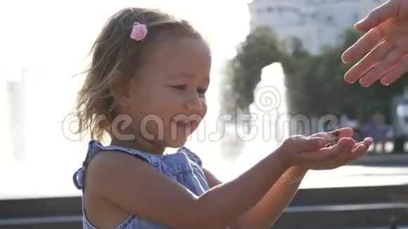 小可爱的女孩在公园喂街鸽在夏天4K慢动作视频的预览图