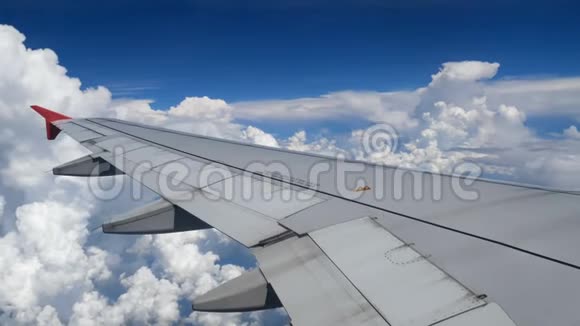 4K镜头飞机飞行在白云和蓝天上空飞行的飞机的翅膀窗外美丽的鸟瞰图视频的预览图