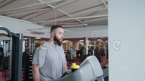 英俊的运动员在健身房的跑步机上锻炼视频的预览图