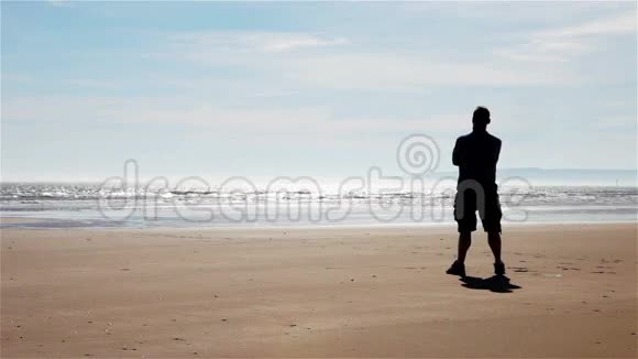 拥抱自由孤独的人站在海滩上视频的预览图
