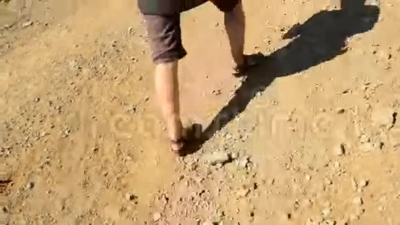 穿着凉鞋走在石路上的女人的脚视频的预览图