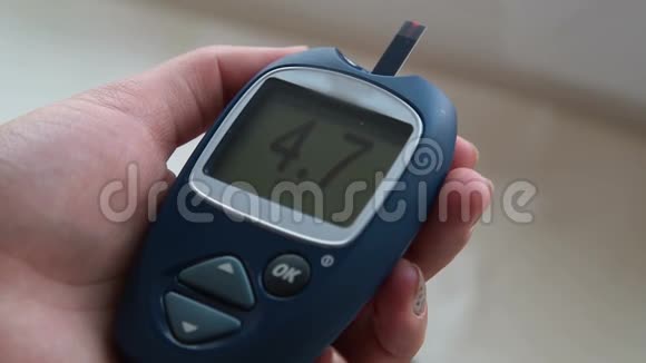血糖仪显示正常血糖的女性手视频的预览图