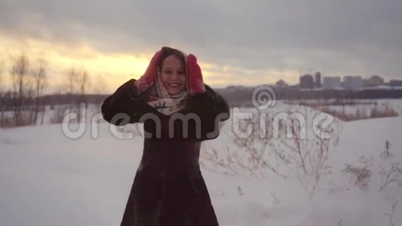 快乐快乐快乐美丽的女人在户外玩在冬天旋转雪天在日落时慢动作视频的预览图
