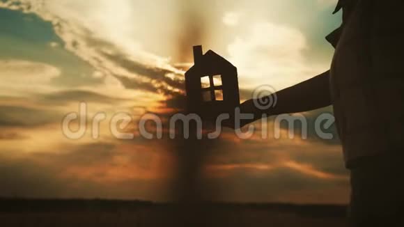 剪影手与纸屋在日落背景视频的预览图